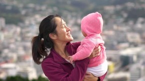 亞洲的母親抱著嬰兒的山頂上