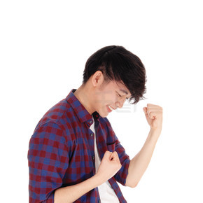 一個快樂的亞洲少年穿著格子襯衫，雙手握拳，因白色背景而被隔離。