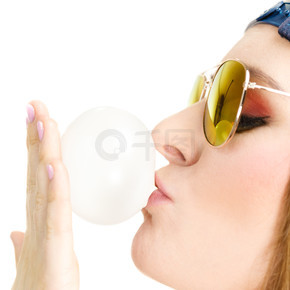 有趣的休閑人概念。時髦的女孩吹氣球。嚼泡泡糖。年輕的女士有漂亮的太陽鏡。時髦的女孩吹氣球。