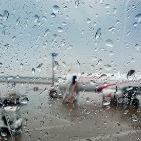 飛機舷窗上雨水滴的特寫照片。飛機舷窗上雨水滴的特寫圖