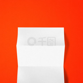 空白折疊白色 A4 紙樣機模板隔離在紅色背景上。紅色背景上的空白折疊白色 A4 紙樣機模板