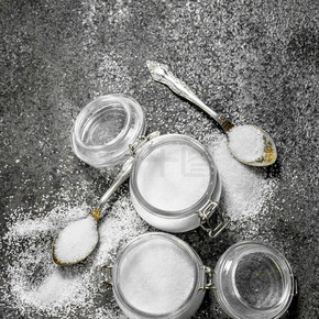 在罐子和勺子里放鹽。在質樸的背景下.. 罐子和勺子里的鹽。