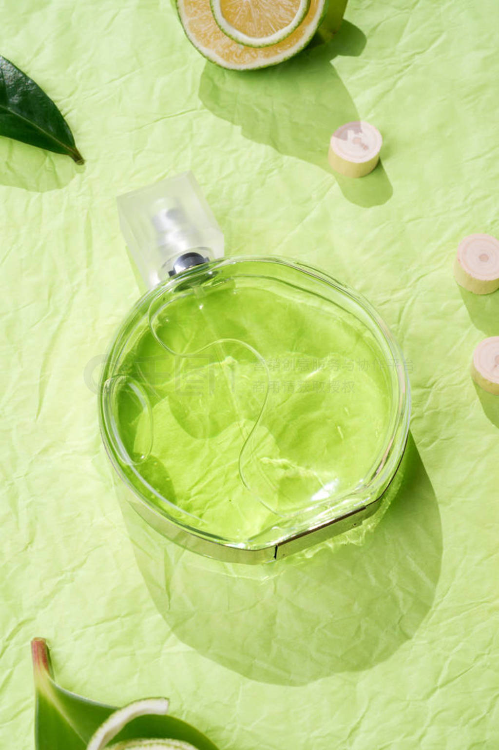 perfume bottle around ingredients on green background.