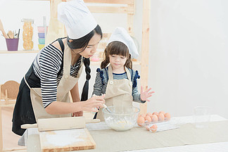 亞洲的母親和她的女兒正在準備面團度假在廚房做蛋糕
