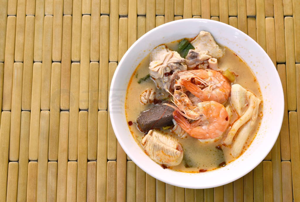 boiled shrimp and chicken with herb in Thai spicy tom yum soup