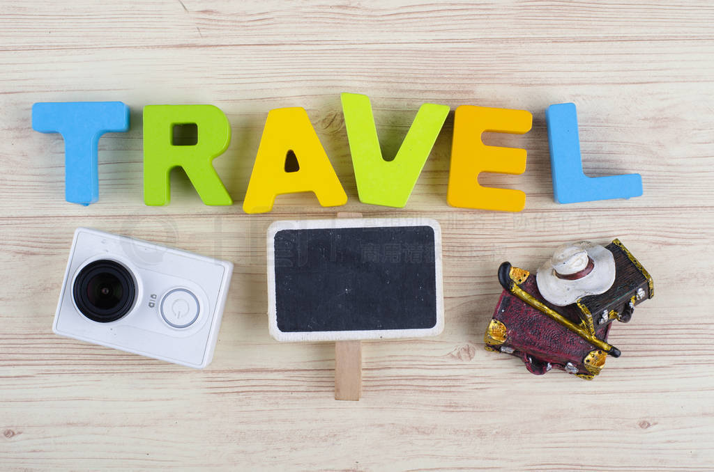 word TRAVEL with accessories on wooden background