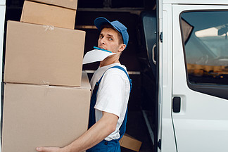裝載機在統一持有包裹的包裹，送貨服務男子站在車輛，男性交付，快遞或運輸工作的紙板包裝