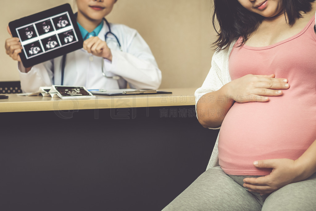 医院或诊所的怀孕顾问的愉快的孕妇参观妇产科医师医生医生检查孕妇的肚子，婴儿和母亲的保健检查妇科的概念孕妇和妇科医生在医院的医生