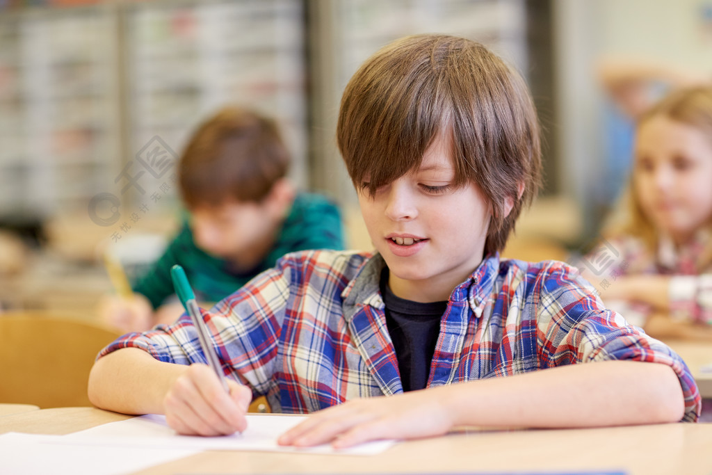 教育,小学,学习和人们观念-组的学校孩子们用笔和笔记本在教室里写