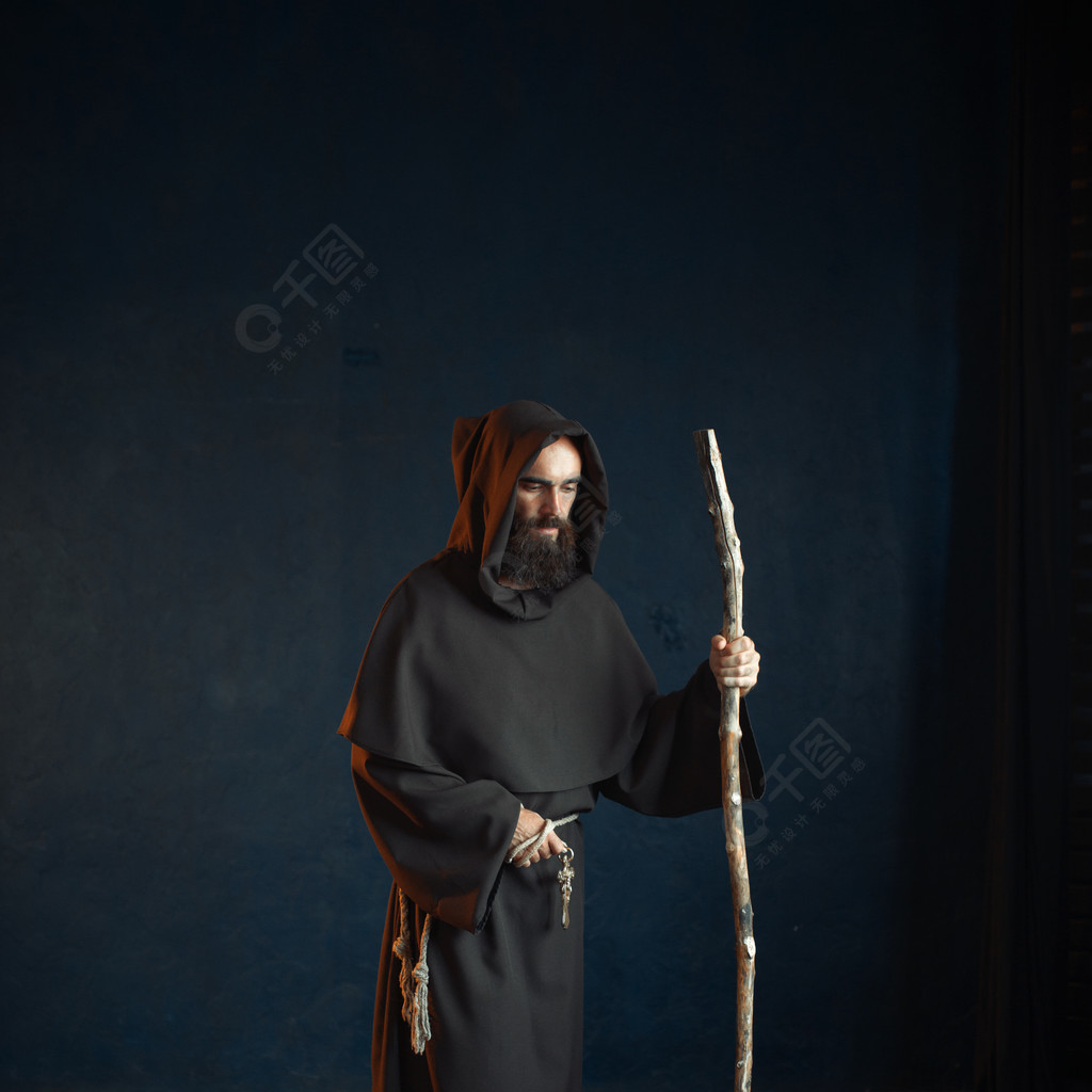 黑长袍的中世纪修士有敞篷的基于棍子,宗教黑斗篷的神秘男修道士