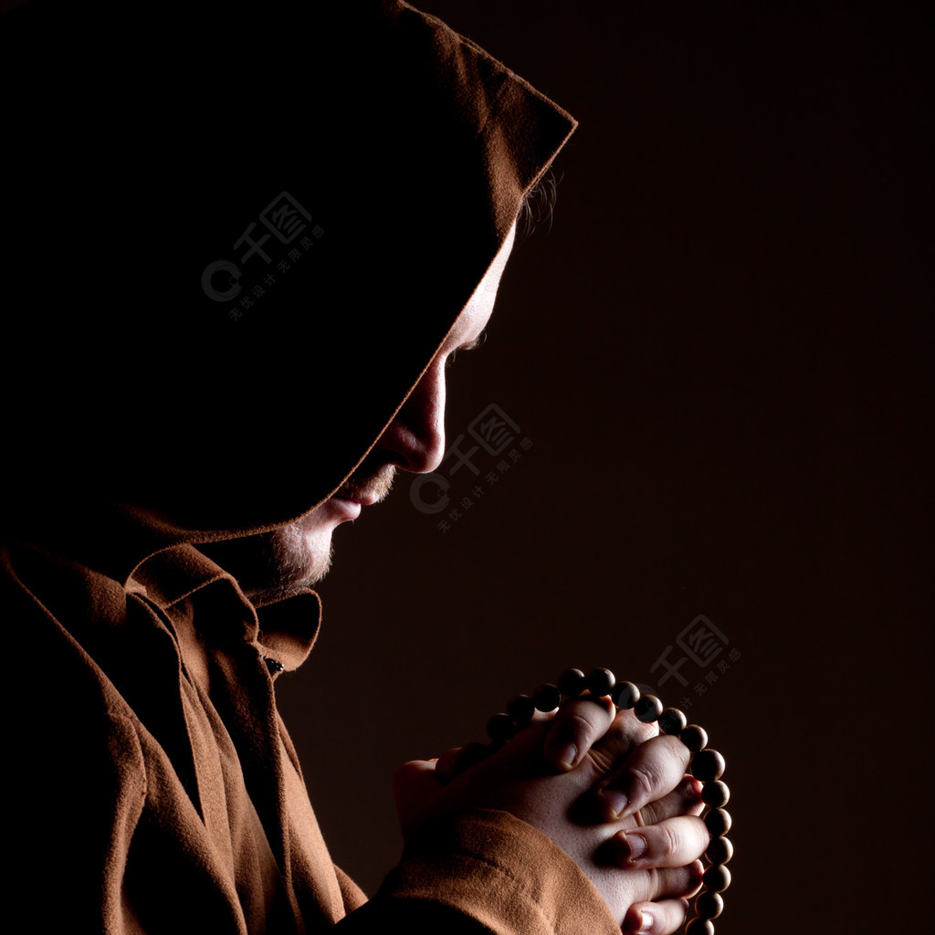 僧侣穿着长袍双手合十祈祷