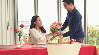 浪漫的情侶在餐廳送禮物給情人幸福的情侶的生活方式