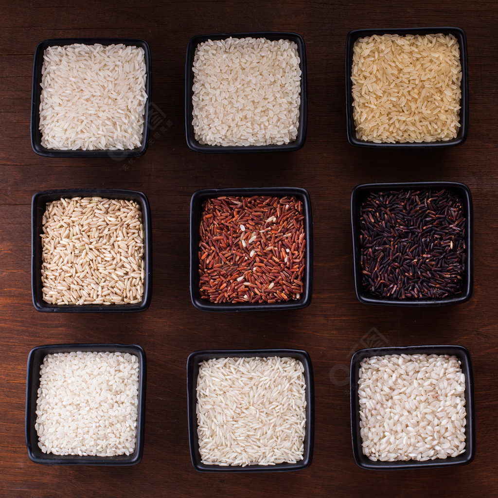 米的各种各样的类型在黑碗的在木桌上各种大米