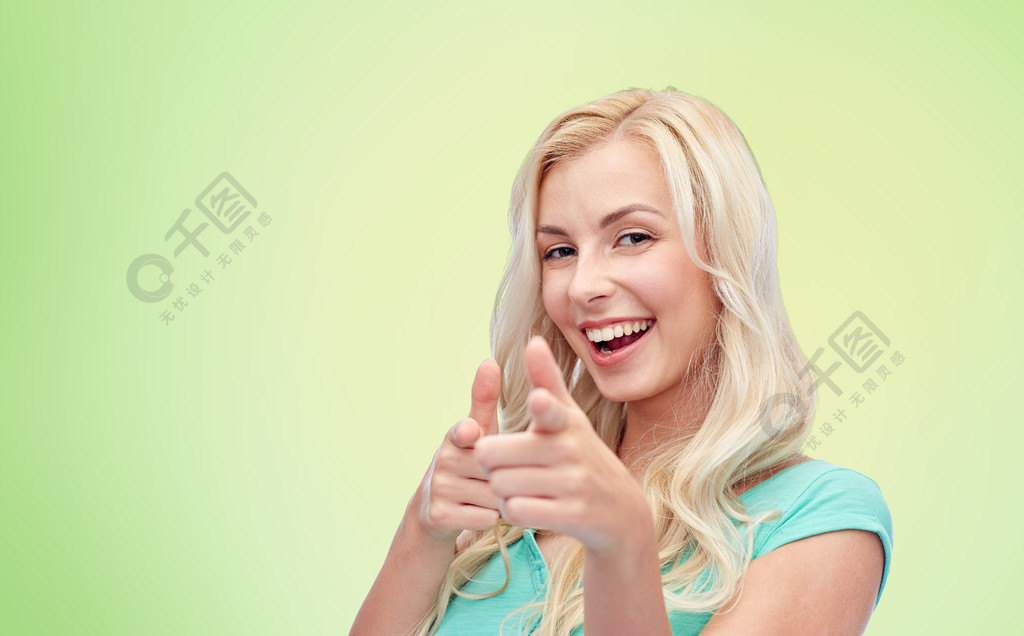 手势和人们的观念-快乐微笑的年轻女子或少女手指指向你在绿色的自然