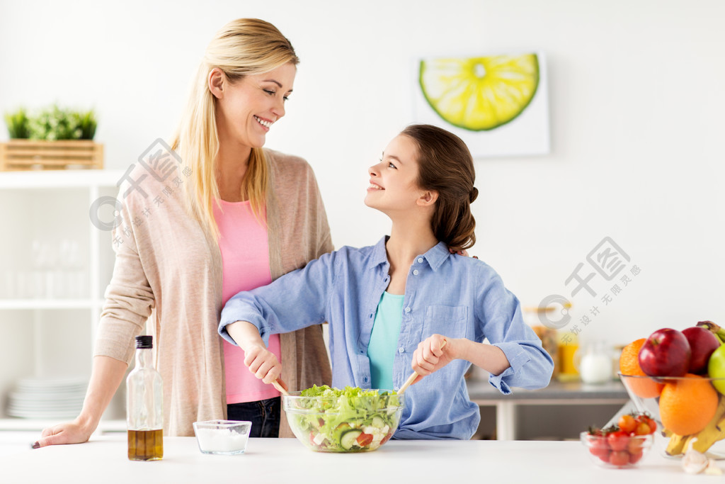 食品,健康饮食,家庭和人们的观念—幸福的母亲和女儿在家里做饭