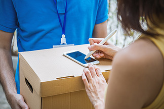 女人附加標志簽名后接受從送貨員，接收盒交貨接收和交付概念