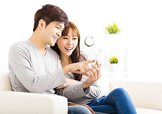幸福夫妻看著在客廳里的智能手機