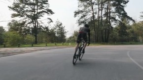 运动型自行车在自行车上坡的鞍上艰难地从马鞍上冲刺。自行车概念。慢动作