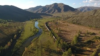 按照旅客列车镜行河附近。北蒙古多彩如诗如画的独<i>特</i>景观。美丽的秋天自然。黄色、 绿色的田野、 山高. 