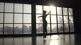 一个优雅的芭蕾舞演员的剪影与古典芭蕾舞蹈和高弹跳在阳光下。慢动作