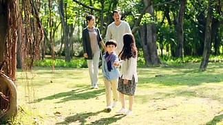 亚洲家庭与两个孩子放松<i>步</i><i>行</i>在公园
