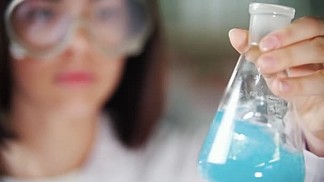 <i>化</i><i>学</i>实验室里的年轻女子拿着烧瓶液