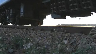 旅客列车经过相机。火车沿着铁轨特写移动轮子。特写镜头的客运火车路过。乘火车旅行的舒适.