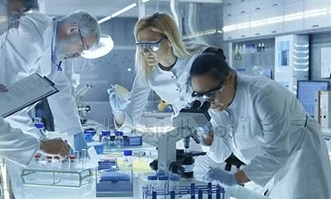 医学研究的科学家团队对新一代疾病治愈。他们使用显微镜、 试管、 微管吸吮和写作下来分析结果。实验室看上去很忙的明亮的和现代.