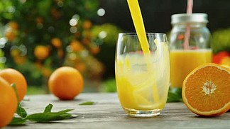将橙汁倒入玻璃杯的超慢速运动