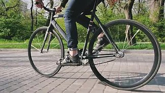 男子骑固定的齿<i>轮</i>自行车 