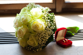 新娘手捧花和窗户上放着戒指的盒子