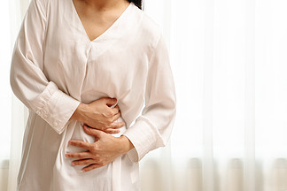 年轻女子患腹痛感觉肚子疼，在白色背景PMS症状