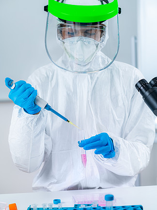 电晕病毒疫苗研究，在研究所实验室工作的科学家，拿着微量移液器。实验室中的冠状病毒疫苗研究