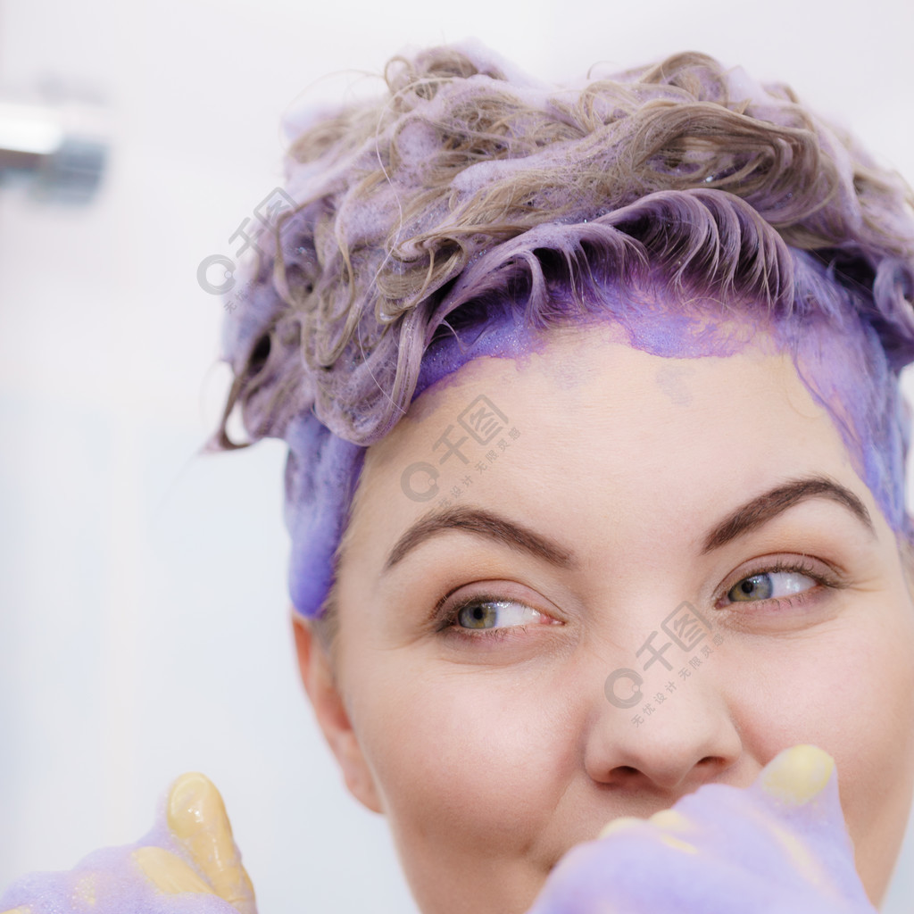 女人戴着乳胶防护手套在她的金发上涂抹紫色调色剂洗发水家庭护理染发