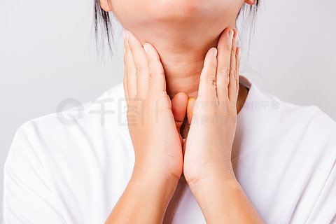 亚洲美女喉咙痛或甲状腺问题,她在白色背景下用手触摸病颈,有复制空间