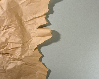 薄荷棕色纸，边<i>缘</i>撕裂，灰色背景上有阴影。设计师的抽象创意背景，复制空间