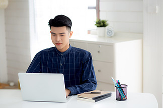 年轻的商人在家工作，办公桌上的笔记本电脑，自由职<i>业</i>男性坐在家里使用笔记本进行交流和放松，<i>创</i><i>业</i>企<i>业</i>家，新常态。
