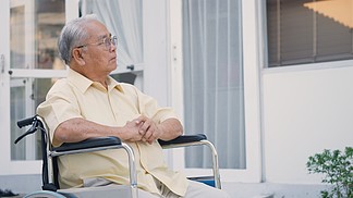 残疾老人在康复中心独自坐在轮椅上，肖像快乐的亚洲一代在家户外后院填补孤独等待照顾痴呆症和阿尔茨海默症