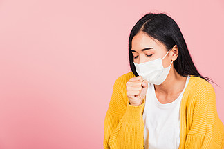 亚洲美丽的年轻女性戴着医用口罩保护预防感<i>染</i>冠状病毒，COVID-19 她咳嗽打喷嚏，工作室拍摄在粉红色背景下被隔离，医疗保健概念