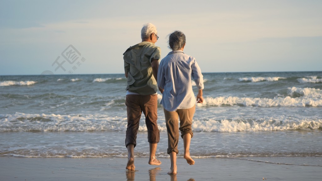 快樂的亞洲活躍老年男女夫婦的生活方式跑到海灘上享受有趣浪漫的老年