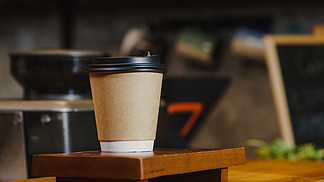 拿走热咖啡纸杯给站在咖啡厅吧台后面的消费者。业主小企业、餐饮、服务理念。