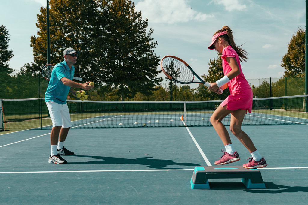 有年轻女孩的网球教练在网球训练