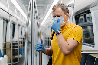 男乘客水平拍摄咳嗽，呼吸困难，戴着一次性口罩和手套，站在公共交通、地铁上，预防冠状病毒。公共卫生解决方案