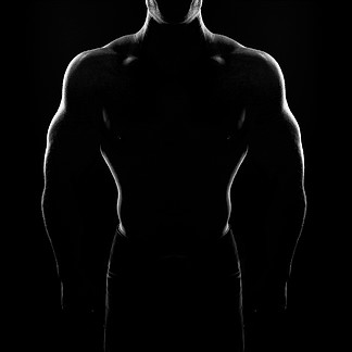 健美运动员摆姿势。英俊的力量运动的家伙男性。黑色背景上的健身<i>肌</i><i>肉</i>发达的身体。黑白照片