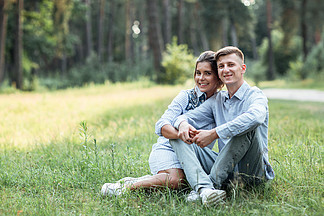 室外拍摄的年轻幸福情侣相爱坐在大自然的 i