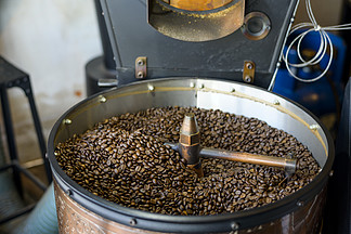 咖啡豆在咖啡店的烘焙机中烘<i>烤</i>。 .咖啡豆正在咖啡店的烘焙机中烘焙
