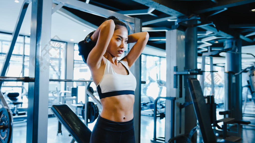美丽的年轻亚洲女士在健身课上做举重杠铃脂肪燃烧锻炼。六包运动员、女运动员休闲活动、功能训练、健康生活方式概念。