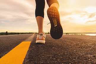 运动员在马拉松和健身的日落训练中在公路上奔跑。女人在户外锻<i>炼</i>的运动模糊