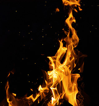 黑色背景中燃烧着高火和火花的木头