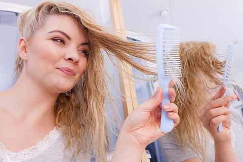 金发女孩在早上照顾刷新她的发型护发概念在浴室里梳长发的女人